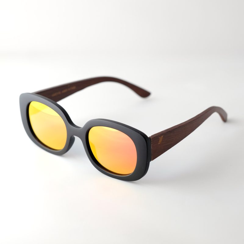 Bucharest Sunset bamboo sunglasses open on a white background. They have orange reflective lenses, black frame and brown arms