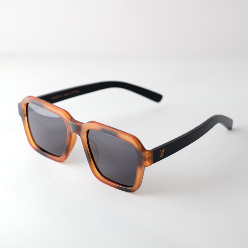 Carpathia bamboo sunglasses, opened, on a white background. tortie frames, dark lenses.